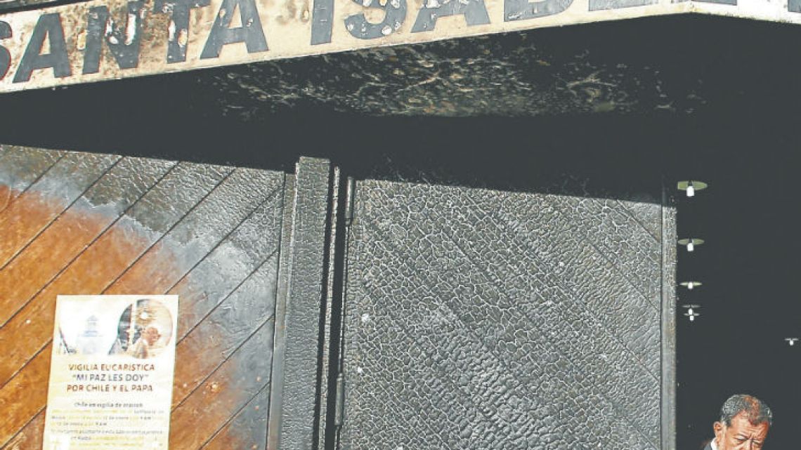 A Chilean official exits the Santa Isabel de Hungria Catholic Church, passing through a door damaged in an overnight attack in Santiago. On Thursday night, three churches in the capital were attacked with fire bombs, with leaflets dropped at the scene against the upcoming visit of Pope Francis, and calling for a “free” Mapuche nation. Nobody was injured or arrested.