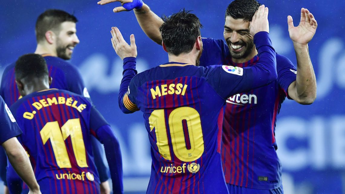 Lionel Messi celebrates with Luis Suarez after scoring Barcelona's fourth goal against Real Sociedad on January 14.