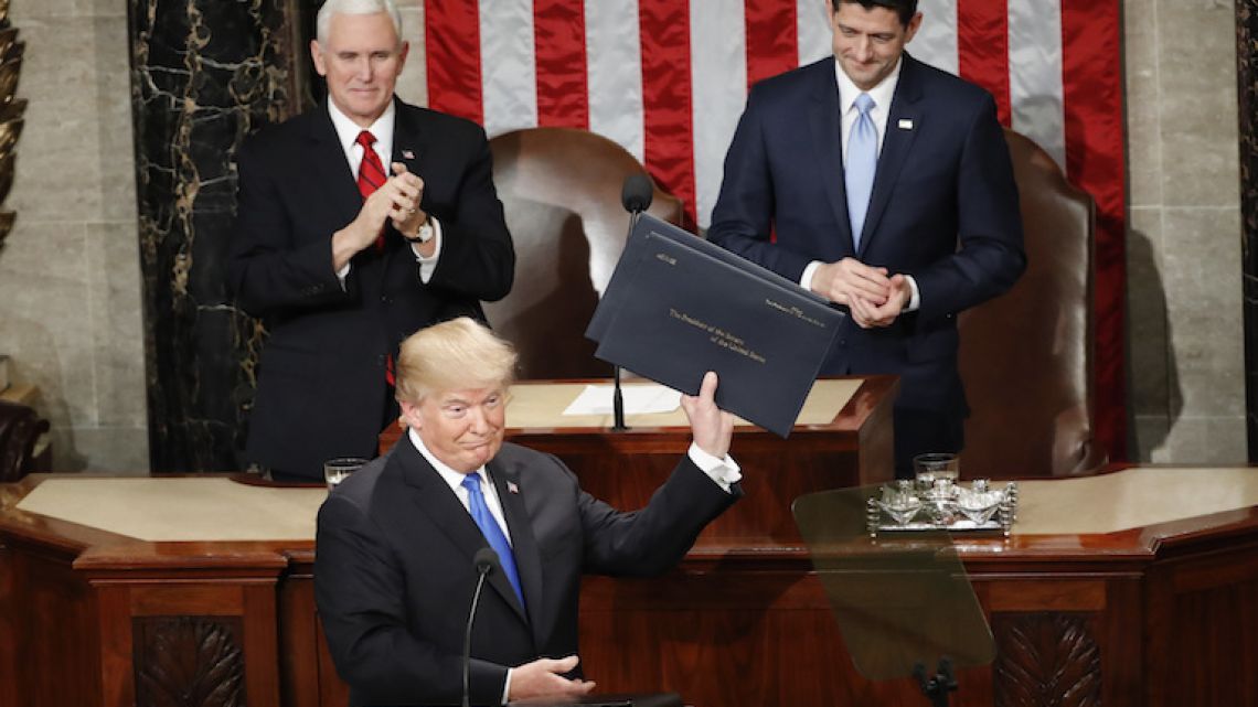 United States President Donald Trump holds up copies of his speech before the State of the Union address to a joint session of Congress on Capitol Hill in Washington on Tuesday night.