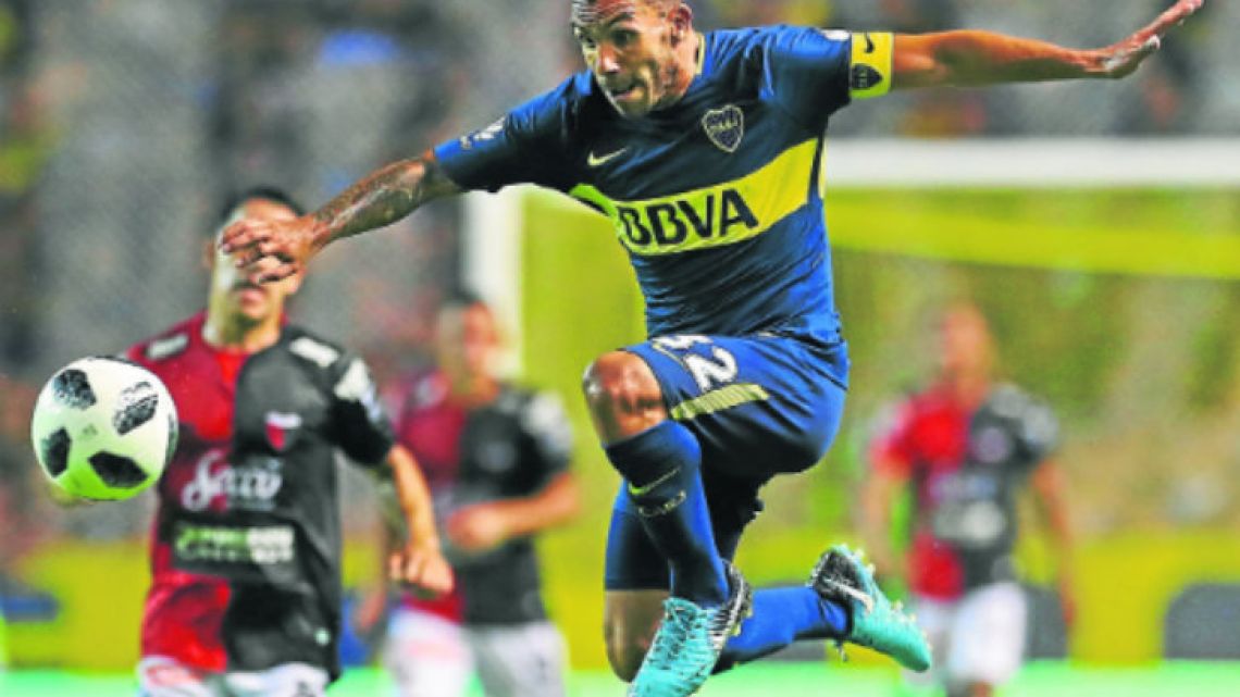 Boca Juniors forward Carlos Tevez jumps over a strong challenge from Atlético Colón defender Germán Conti (right), during their Superliga clash at La Bombonera last weekend.