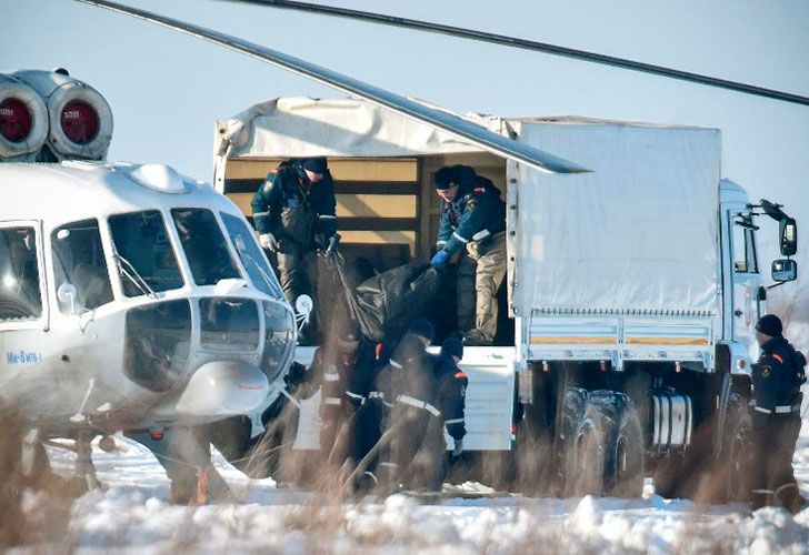 Un helicóptero se lleva los cuerpos de las víctimas mientras los rescatadores del Ministerio de Emergencia trabajan en el lugar de un accidente aéreo ocurrido el día anterior en el distrito de Ramensky, en las afueras de Moscú