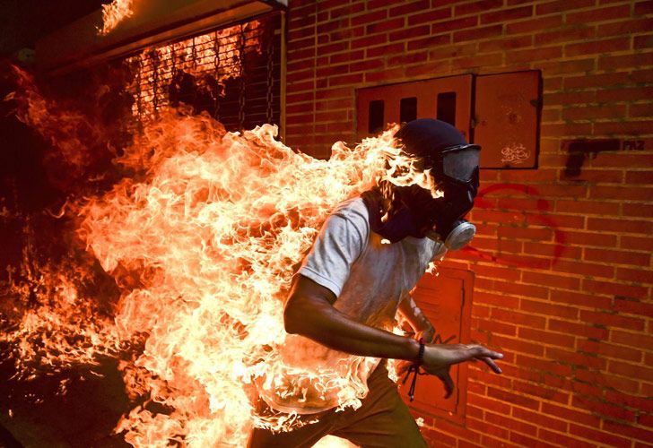 Venezuela Crisis – La crisis de Venezuela: El venezolano Ronaldo Schemidt (41 años) de la agencia France Presse (AFP) capturó la imagen de José Víctor Salazar Balza (28) prendiéndose fuego accidentalmente, mientras se llevaba a cabo una violento choque con la policía a causa de una protesta contra el gobierno del Presidente Nicolás Maduro, en Caracas, Venezuela.