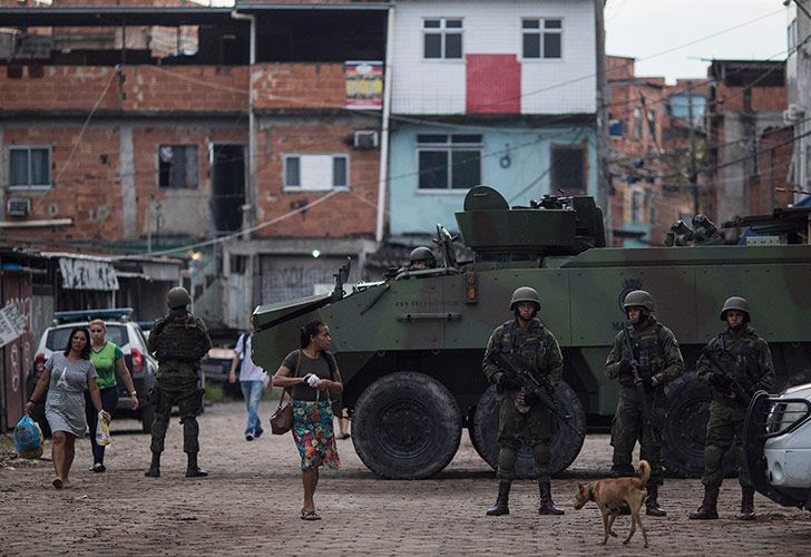 Infantes de marina brasileños hacen guardia al lado de un vehículo blindado durante la operación sorpresa en el barrio marginal de Kelson en Río de Janeiro, Brasil