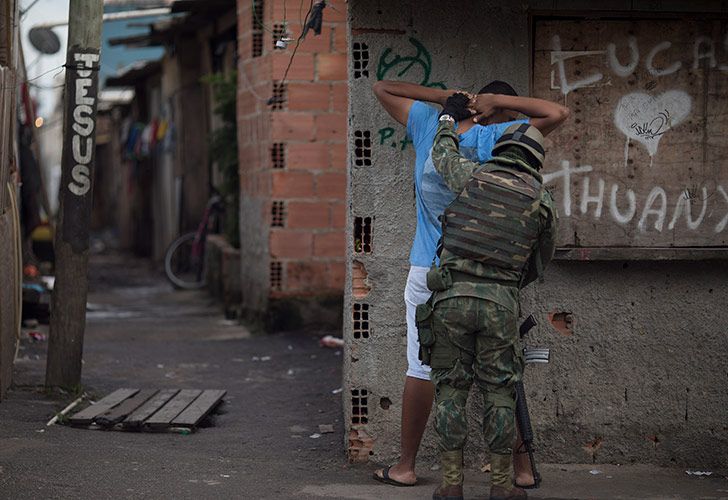 Un marine brasileño registra a un residente durante una operación sorpresa en el barrio marginal de Kelson en Río de Janeiro, Brasil