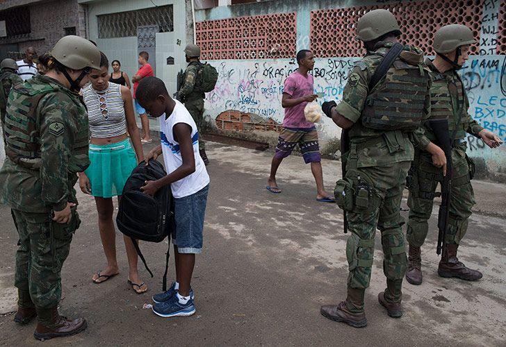 Marina brasileña revisa la mochila de un estudiante durante una operación sorpresa en el barrio marginal de Kelson en Río de Janeiro, Brasil