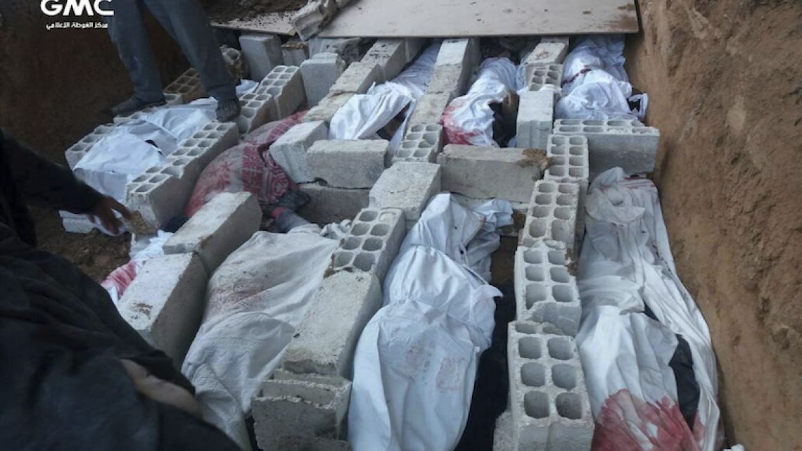 The bodies of Syrians killed during airstrikes and shelling by Syrian government forces in recent days, buried in a mass grave in Ghouta, a suburb of Damascus.