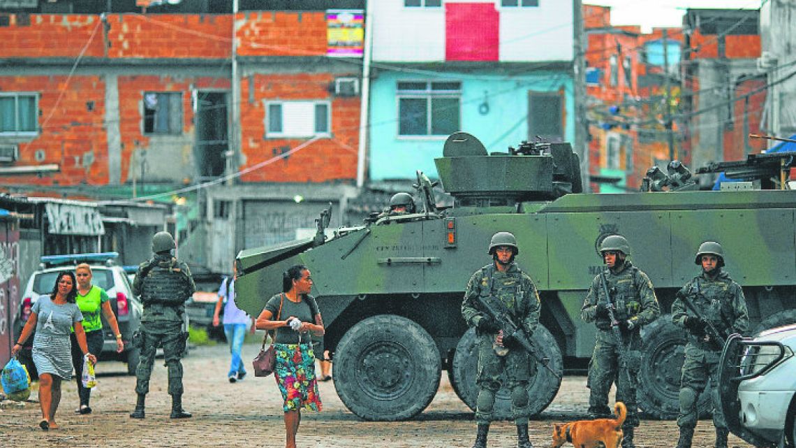 Brazilian marines stand in guard next to an armoured vehicle during an operation in Kelson’s slum in Rio de Janeiro.