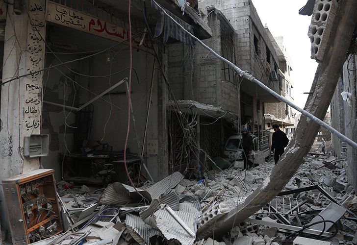 Hombres caminan por una calle destruida en Arbin, en el enclave de los rebeldes de Ghouta Oriental.