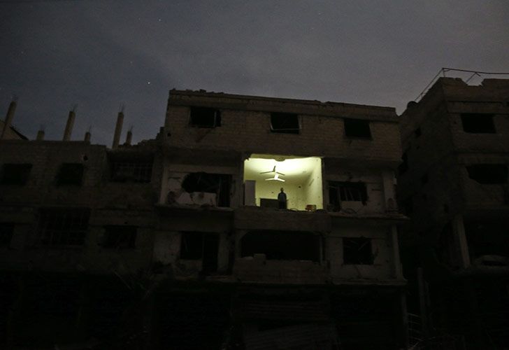 Un hombre se encuentra en un edificio dañado en Hamouria, en el enclave de los rebeldes de Ghouta Oriental.