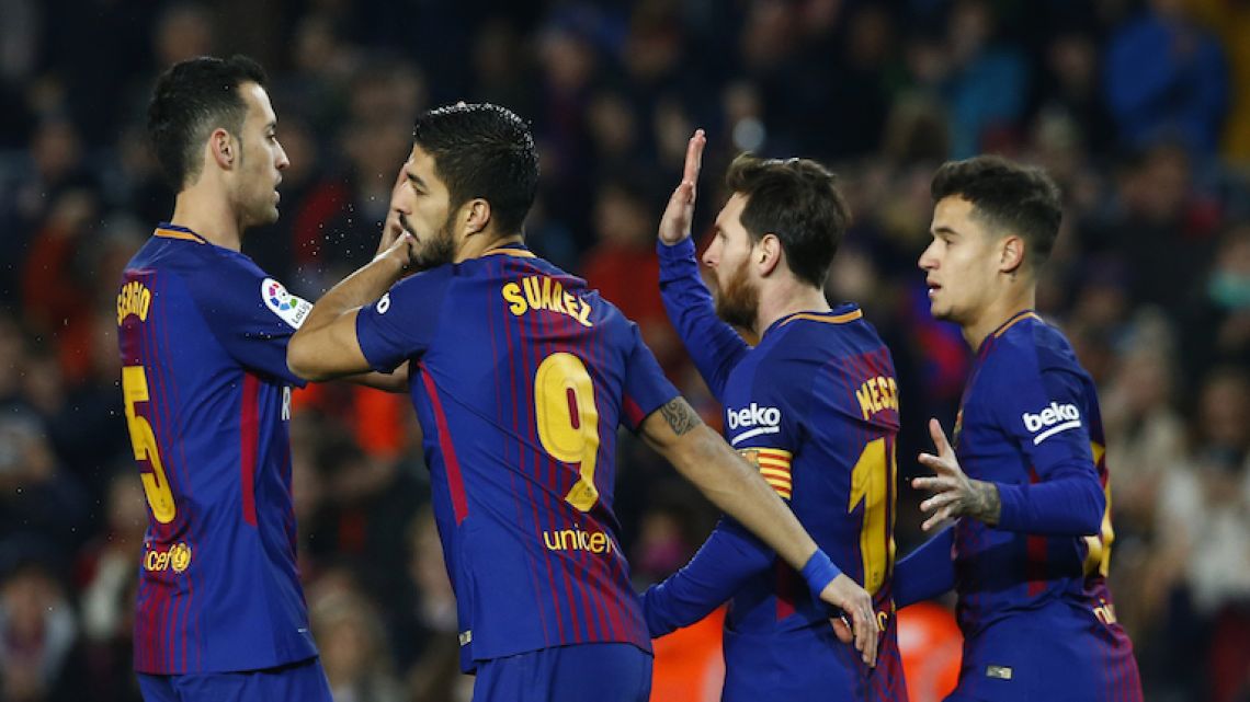 Barcelona players (left to right) Sergio Busquets, Luis Suárez, Lionel Messi and Philippe Coutinho celebrate after Suárez scores against Girona on Saturday.