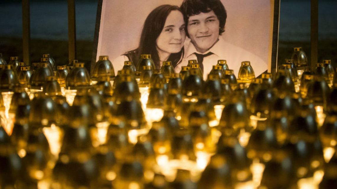 Candles and lights are placed during a protest in memory of murdered journalist Jan Kuciak and his fiancée Martina Kusnirova, seen in the photo, in Bratislava, Slovakia.