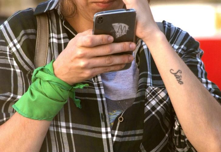  Una mujer en uno de sus brazos lleva el pañuelo representativo en el Día de la Mujer.