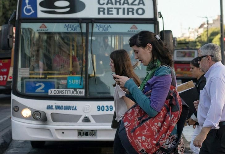 Una mujer se dirige a sus actividades diarias con el pañuelo representativo en el Día de la Mujer.