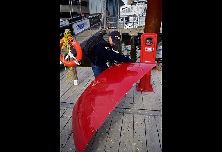 Un investigador examina una parte de un helicóptero que se estrelló en el East River de Nueva York el domingo.