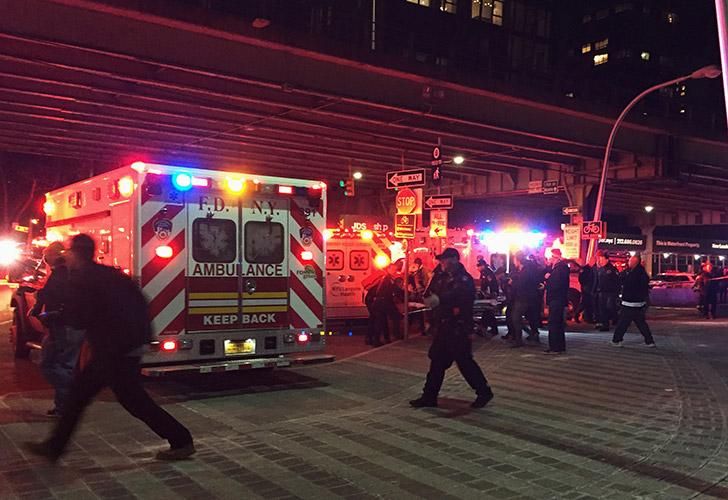 Un helicóptero es levantado por una grúa desde el East River hacia una barcaza.