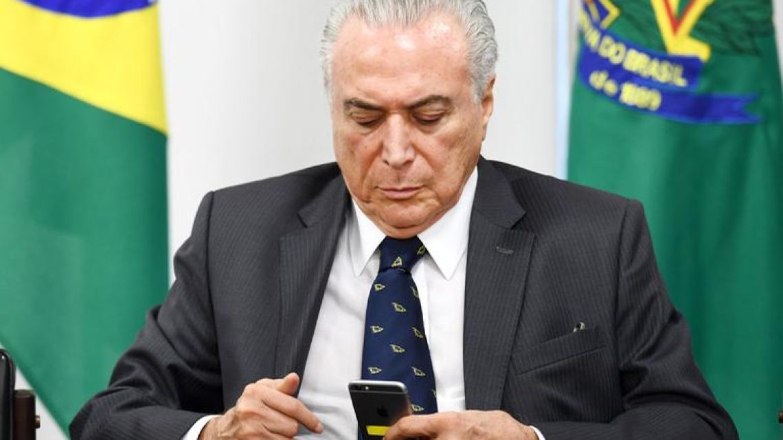 Brazilian President Michel Temer looks at a mobile phone, at the Planalto Palace in Brasilia.