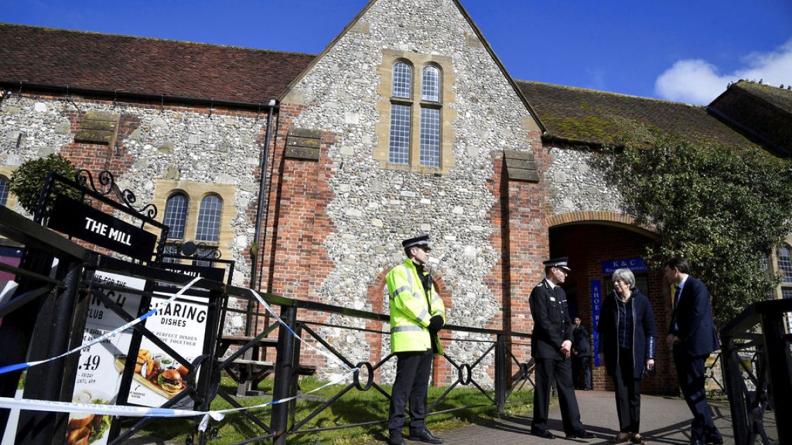 British Prime Minister Theresa may examines the area where former Russian double agent Sergei Skripal and his daughter were found critically ill outside The Mill pub in Salisbury, England on Thursday.