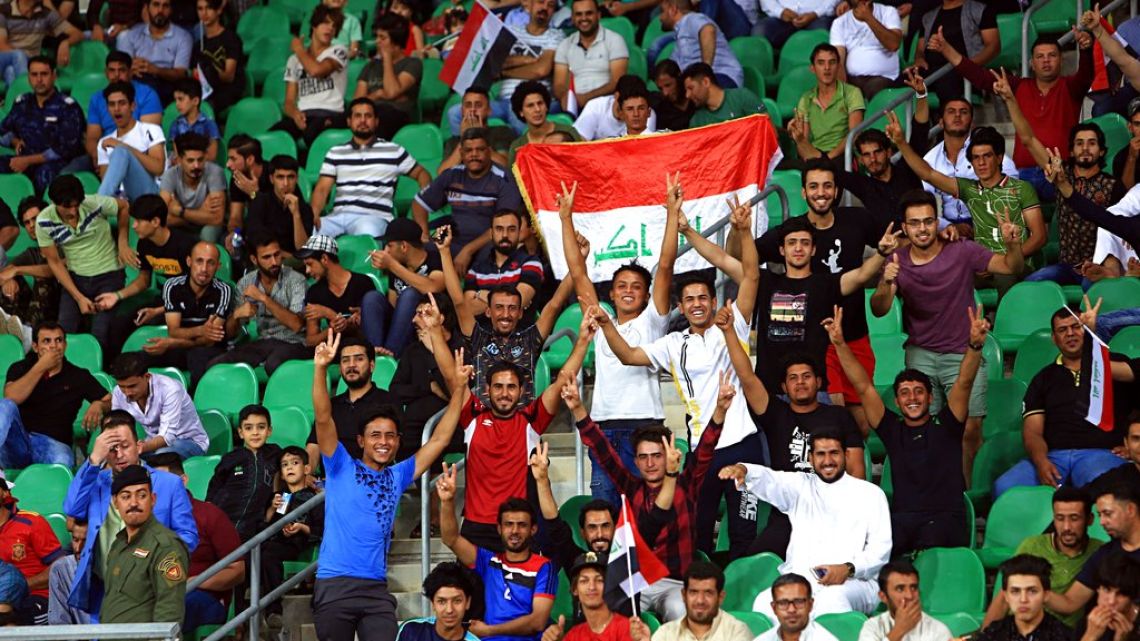 Iraqi football fans display national flags as they cheer during a friendly between Kenya and Iraq in Basra, Iraq last October.