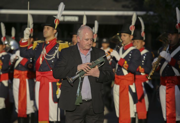 Excombatiente hace sonar el clarín durante la recepción a los familiares de caídos en Malvinas en Ezeiza.