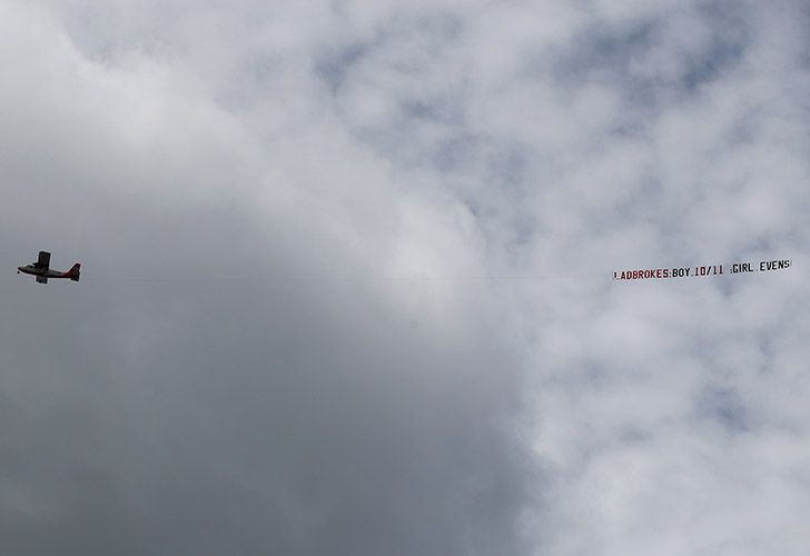 Un aeroplano sobrevuela el Hospital St Mary con una pancarta mostrando las probabilidades del género del bebé real