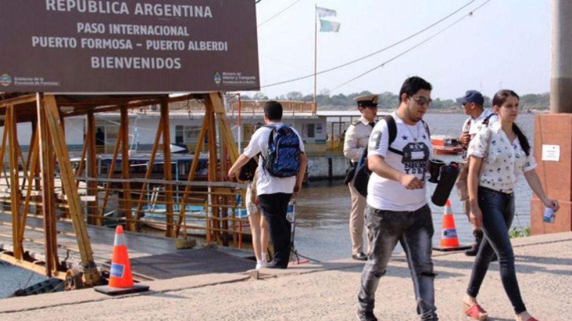 Tourists cross a Argentina-Paraguay border crossing.