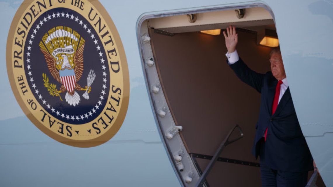 US President waves to a crowd after arriving at Dallas Love Field airport.