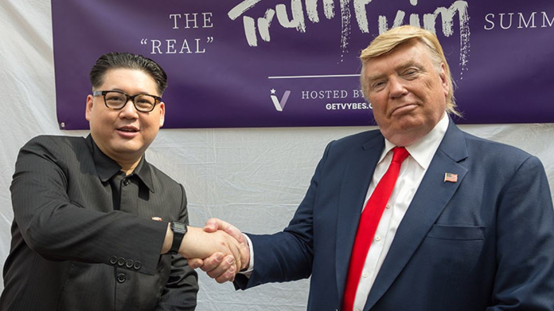 Impersonators of Kim Jong-un and Donald Trump, Howard X (left) and Dennis Alan (right) shakes hands during a promotional event in Singapore.  