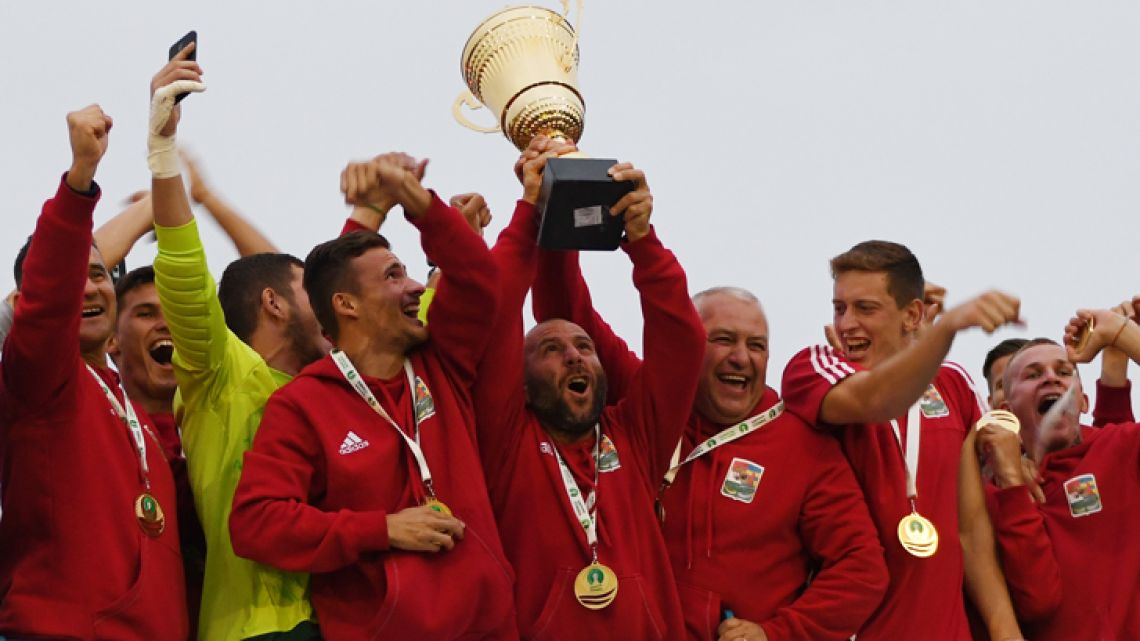 Members of the Karpatalja squad celebrate with the CONIFA alternative World Cup trophy.