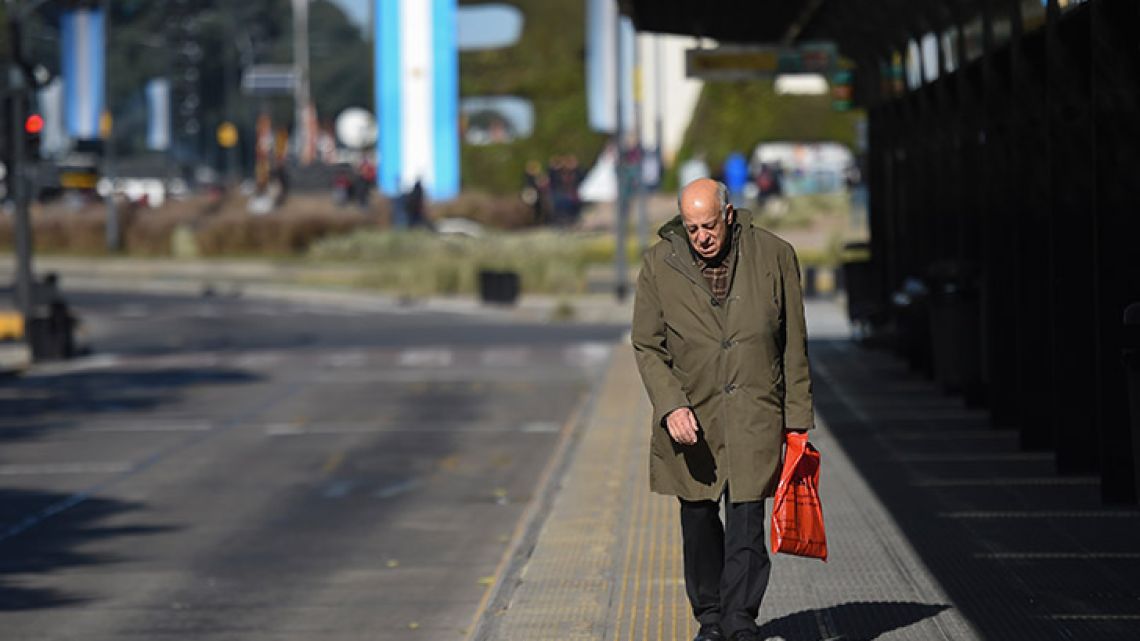 A man walks at an empty bus stop on an empty Avenida 9 de Julio on June 25, 2018, during a 24-hour general strike called by unions.