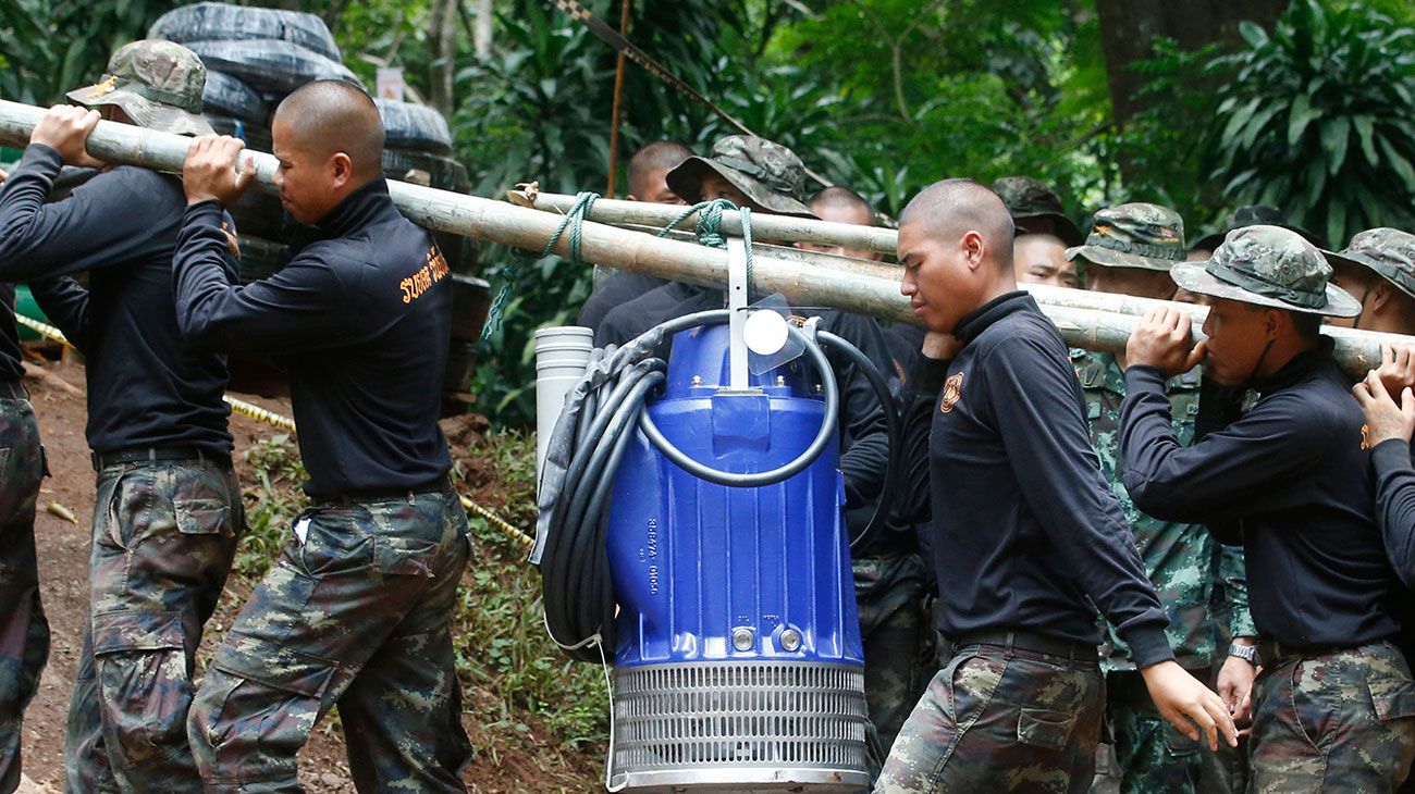 Soldados llevan una bomba para ayudar a drenar el agua de inundación en una cueva donde 12 niños y su entrenador de fútbol han quedado atrapados desde el 23 de junio en Mae Sai, provincia de Chiang Rai, al norte de Tailandia el viernes 6 de julio de 2018. Las autoridades tailandesas están compitiendo para bombear agua desde la cueva inundada antes de que se pronostiquen más lluvias en la región norte.