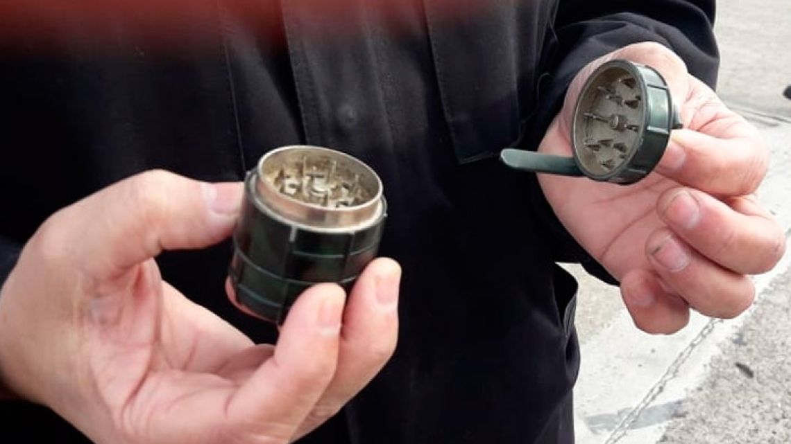 In this photo released by Airport Police, an officer holds a marijuana, or pot, grinder made in the shape of a grenade, which triggered an evacuation of the Astor Piazzolla airport in Mar del Plata on Tuesday.