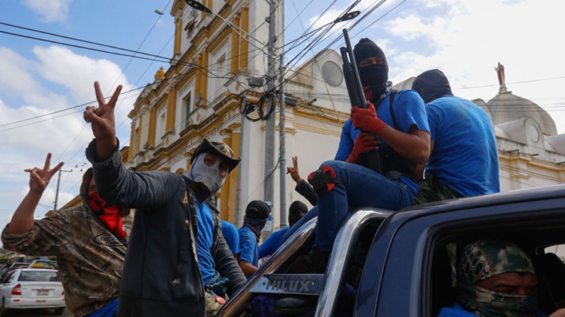 Armed pro-government militia members flash victory signs as they occupy the Monimbo neighbourhood of Masaya, Nicaragua. On Tuesday, Nicaraguan government forces retook the symbolically important neighbourhood that had become a centre of resistance to Nicaraguan President Daniel Ortega's government.