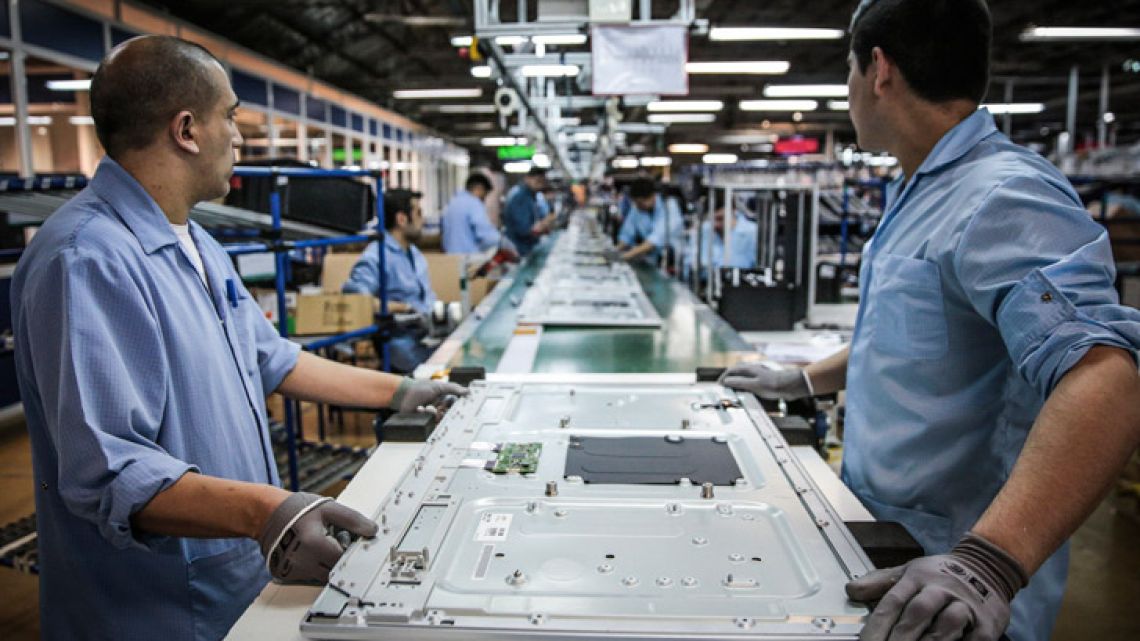 Workers assemble electronics at a factory.