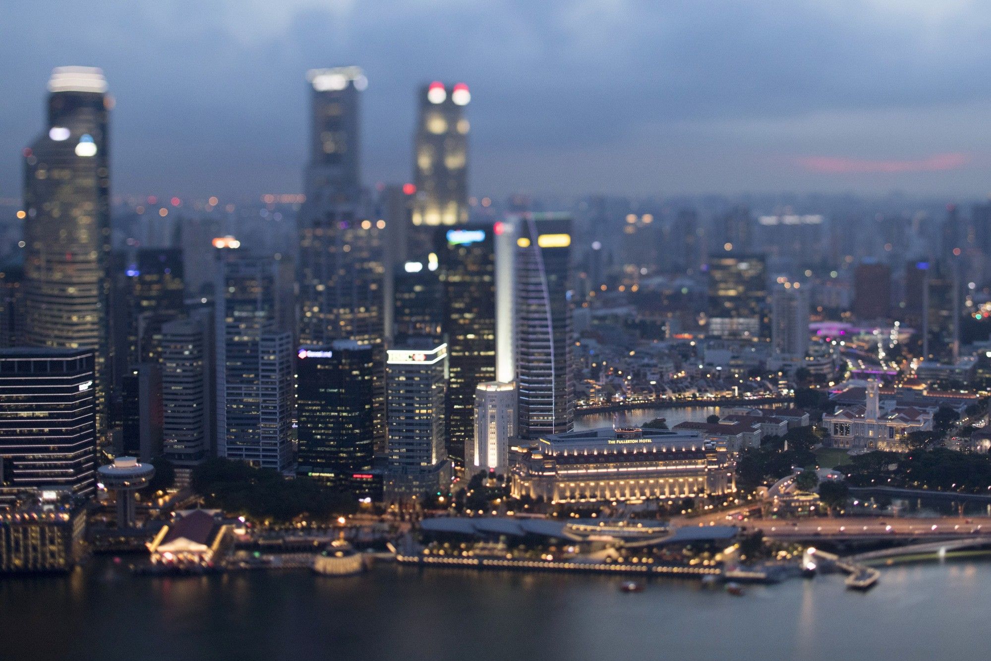 Commercial buildings standing in the central business district are illuminated at dusk in Singapore