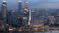 Commercial buildings standing in the central business district are illuminated at dusk in Singapore