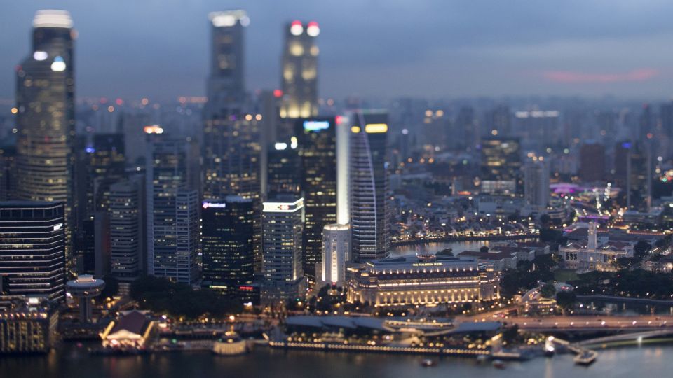 Commercial buildings standing in the central business district are illuminated at dusk in Singapore
