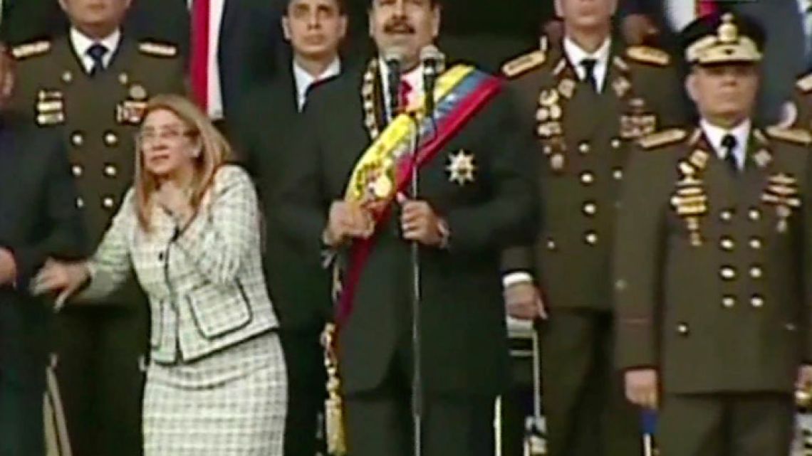 In this still from a video provided by Venezolana de Television, Nicolás Maduro (centre) delivers his speech as his wife Cilia Flores winces and looks up after being startled by an explosion in Caracas on Saturday, August 4, 2018.