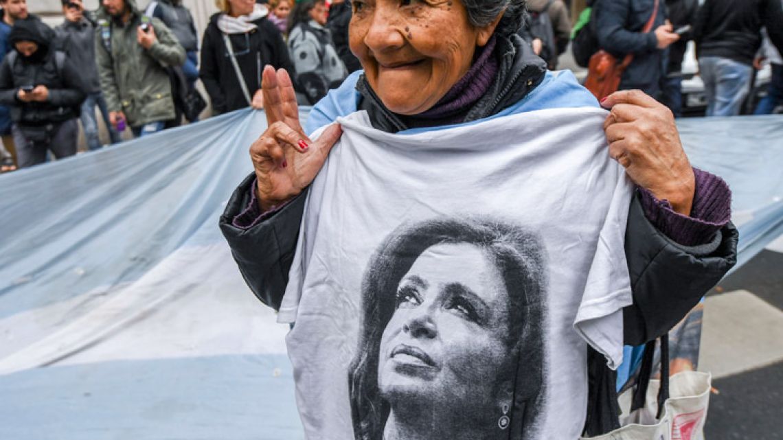 A supporter of former President and current senator Cristina Fernández de Kirchner demonstrates as Federal Police raid one of her properties in the Recoleta neighbourhood of Buenos Aires, on August 23, 2018, as part of the so-called 'bribery notebooks' corruption case.