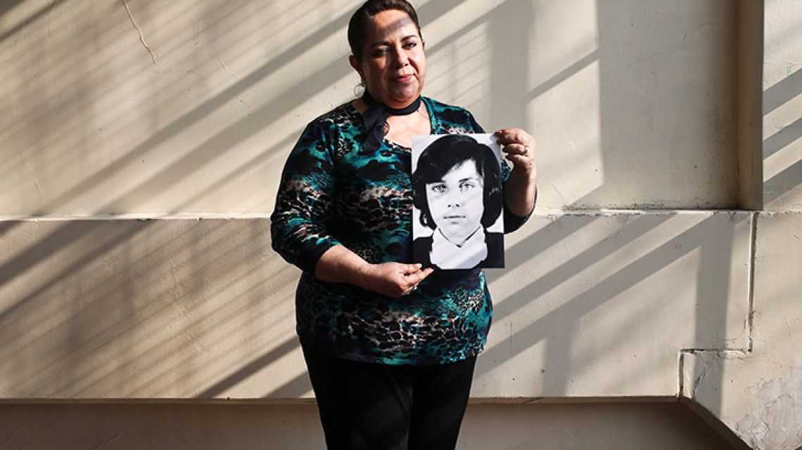Fifty-four-year-old teacher Vittoria E Natto poses for a portrait inside her high school holding a photo of herself when she was nine years old, in Santiago, Chile. Forty-five years after the Chilean coup led by General Augusto Pinochet, there are still stories to tell of the horrors that followed the September 11, 1973, overthrow of president Salvador Allende. That repression is still stamped on the mind of Natto, who uses a pseudonym to write and speak about her history.