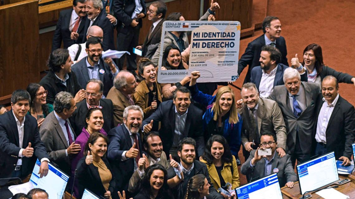 Chilean deputies celebrate as they hold a giant fake Chilean Identity card reading "My identity, my right," after voting for gender identity law, during a session at Chamber of Deputies at the National Congress in Valparaíso, Chile, on September 12, 2018. Chilean deputies approved a gender identity law that allows the change of name and sex in public records from the age of 14, the last step of a five-year-long legislative debate that confronted conservatives with the LGBTI community. 