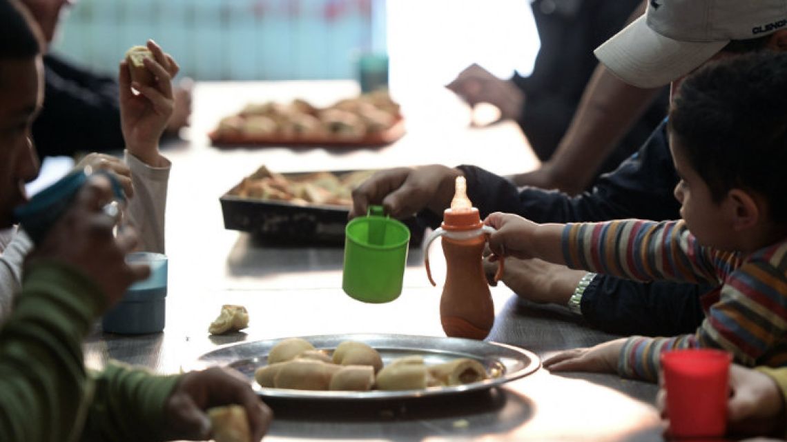 People have a snack at Los Piletones soup kitchen, run by social activists in the Villa Soldati neighbourhood of Buenos Aires.