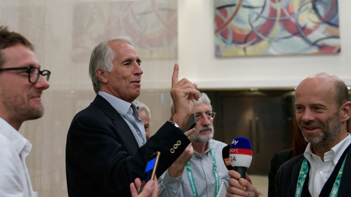 The president of the Italian Olympic Committee Giovanni Malago (second-left) jokes with journalists after the president of the International Olympic Committee (IOC), German Thomas Bach (out of frame) delivered a press conference at the end of an IOC executive board meeting in Buenos Aires on October 4, 2018.  