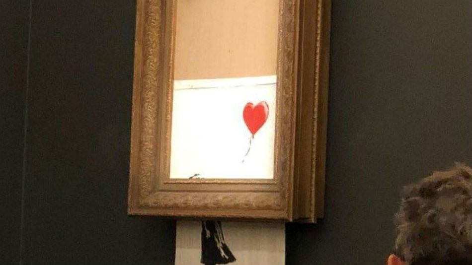 El cuadro de Banksy, destruído ante un auditorio de compradores estupefacto.
