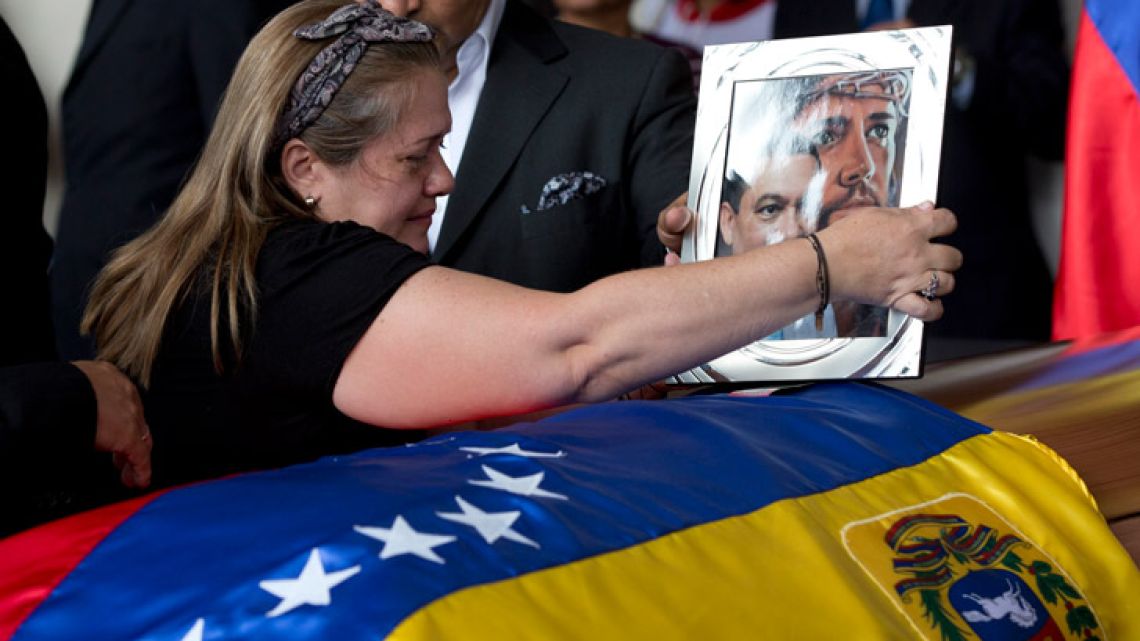 Luz Alban, the sister of opposition activist Fernando Alban places a framed portrait of her brother during a solemn ceremony at the National Assembly headquarters, in Caracas, Venezuela