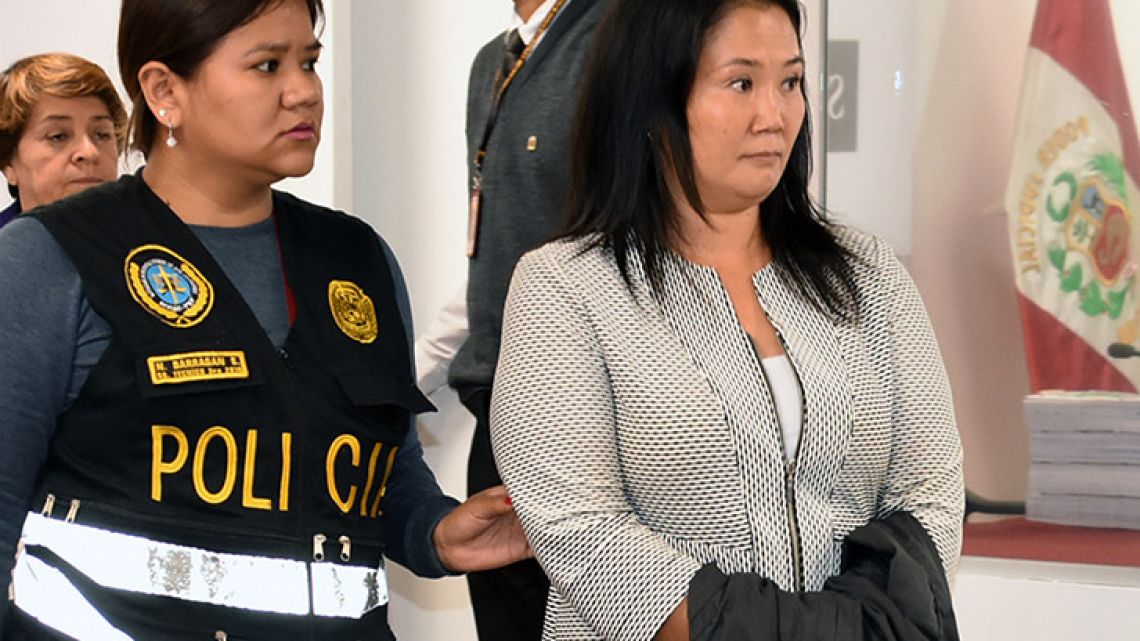 Handout picture distributed by Peruvian Judiciary showing Keiko Fujimori, opposition leader and daughter of disgraced ex-president Alberto Fujimori, being escorted by police officers in a Judiciary office, in Lima, following her arrest on October 10, 2018, for alleged money laundering involving Brazilian construction giant Odebrecht.