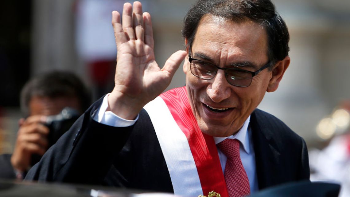 Peru's newly-sworn in President Martin Vizcarra waves as he makes his way to the Government Palace, in Lima, Peru. 