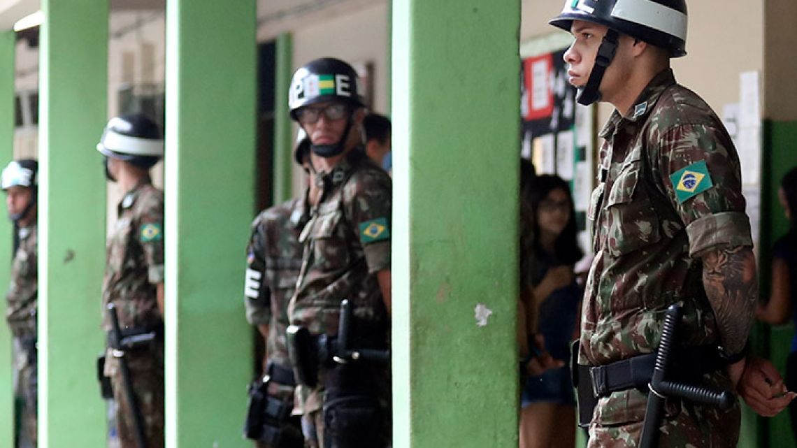 Brazilian soldiers stand guard as people wait in line to cast their votes at the polling centre in Rio de Janeiro, Brazil October 28, 2018 Brazilians will choose their president today during the second round national election between the far-right firebrand Jair Bolsonaro and leftist Fernando Haddad. 