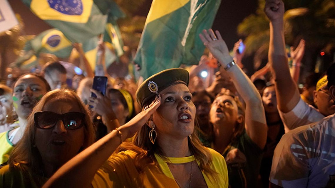 A supporter of Jair Bolsonaro salutes during a celebration in front of his residence after he was declared the winner of Brazil's election run-off, in Rio de Janeiro.