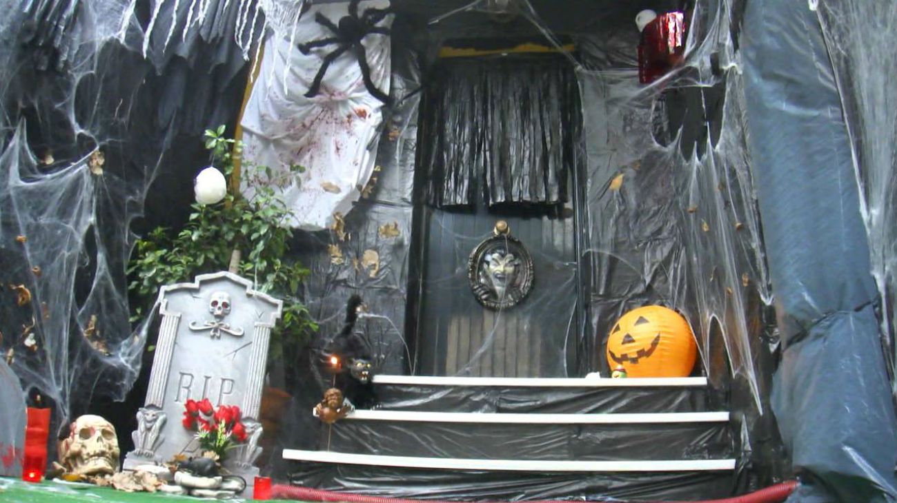 Una casa decorada para la fiesta de Halloween con calaveras; telas de arañas y calabazas.