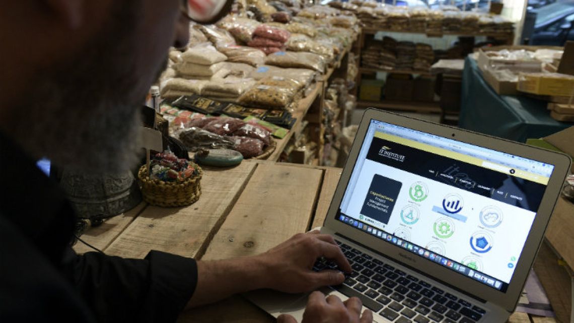 Businessman Fernando Hechtlinger uses his laptop at his natural foods grocery store in Buenos Aires.
